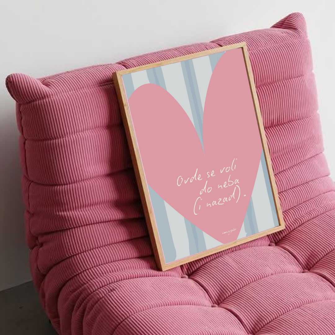 Pink cushioned chair with a framed picture of a heart on a white wall