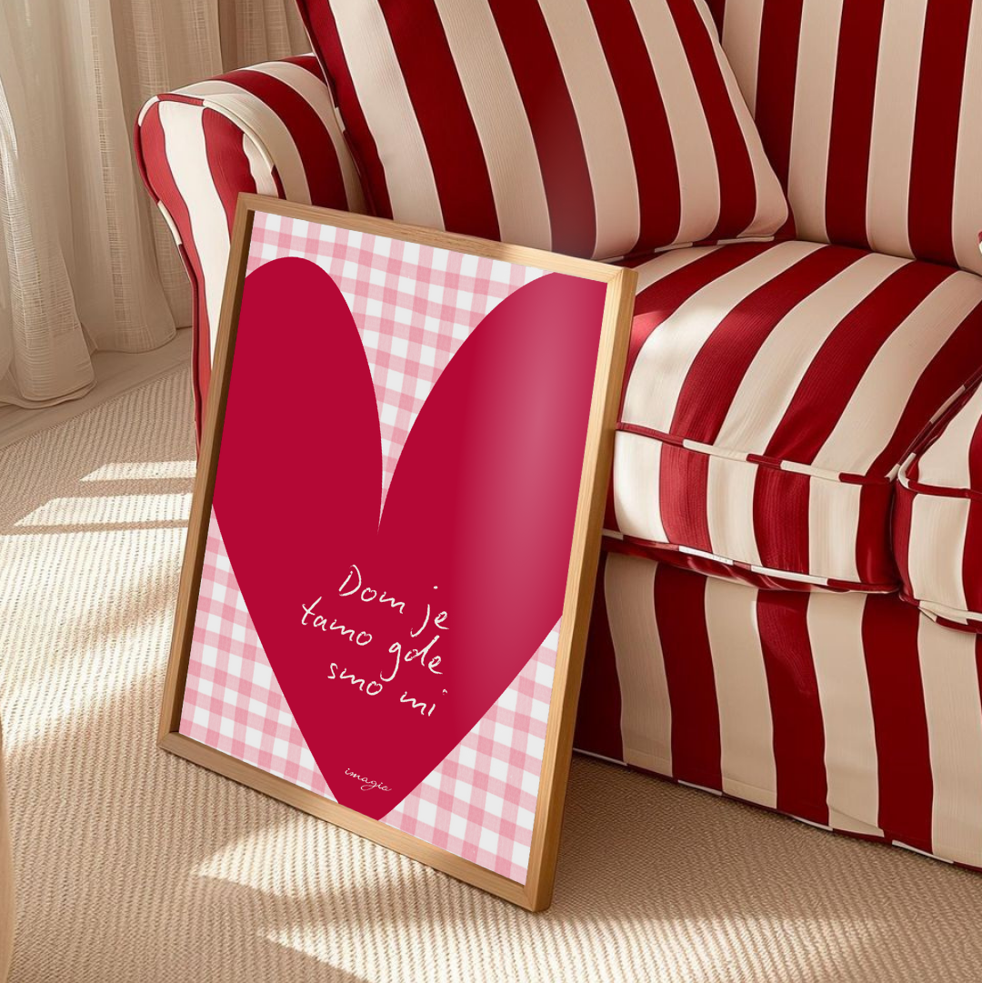 Framed pink heart-shaped poster with text on a red and white striped sofa.