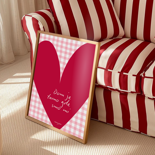Framed pink heart-shaped poster with text on a red and white striped sofa.
